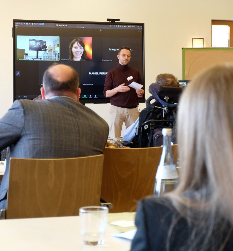 Decorative picture, showing Matthias Kadler in front of a screen opening the annual assembly 2023.