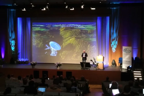 Anton Zensus delivering the Schwarzschild lecture on 10 September 2024, about the history and current development of radio astronomy and about his own scientific pathway. Prof. Zensus talks in a huge lecture hall in front of a big screen showing the Effelsberg dish. Image credit: Christoph Wendel